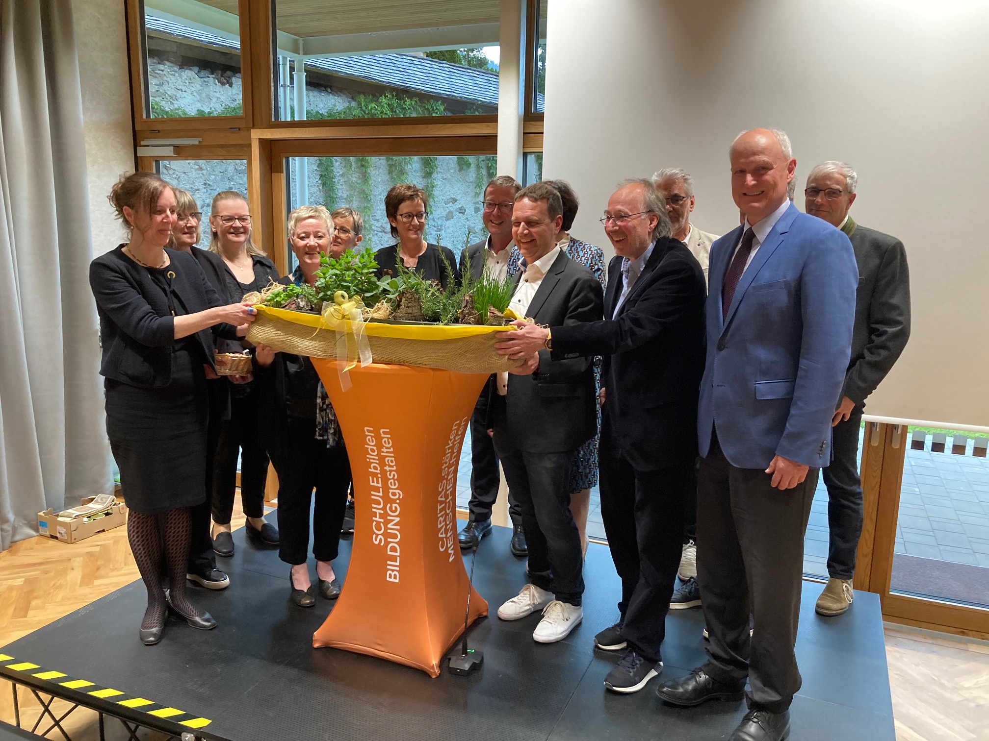 "Schl&uuml;ssel&uuml;bergabe" in Form eines Kr&auml;uter-Kistl durch den Pfarrkirchenrat an das Bildungshaus-Team. Foto: Stangl