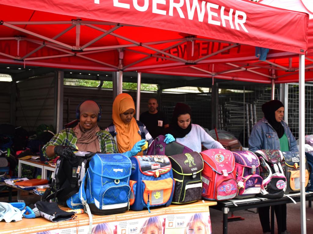 BewohnerInnen des Fl&uuml;chtlingsheims Reichenau reinigen die Schultaschen und machen sie "fit" f&uuml;r viele weitere Jahre. Foto: Land Tirol/Knabl