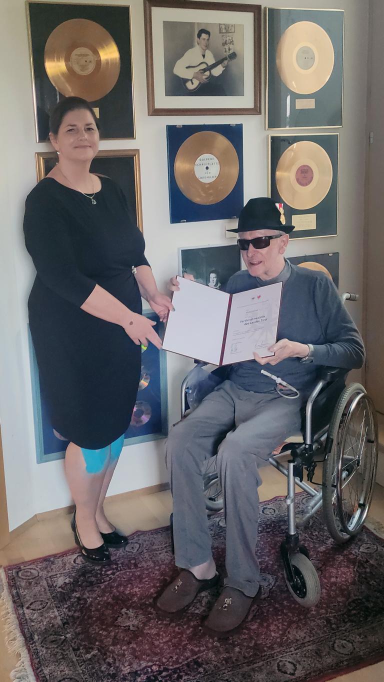 BH Olga Reisner besuchte den mittlerweile im Rollstuhl sitzenden und erblindeten Louis Holzer bei ihm zuhause in Graz und &uuml;berreichte ihm dort die Verdienstmedaille des Landes. Foto: Land Tirol