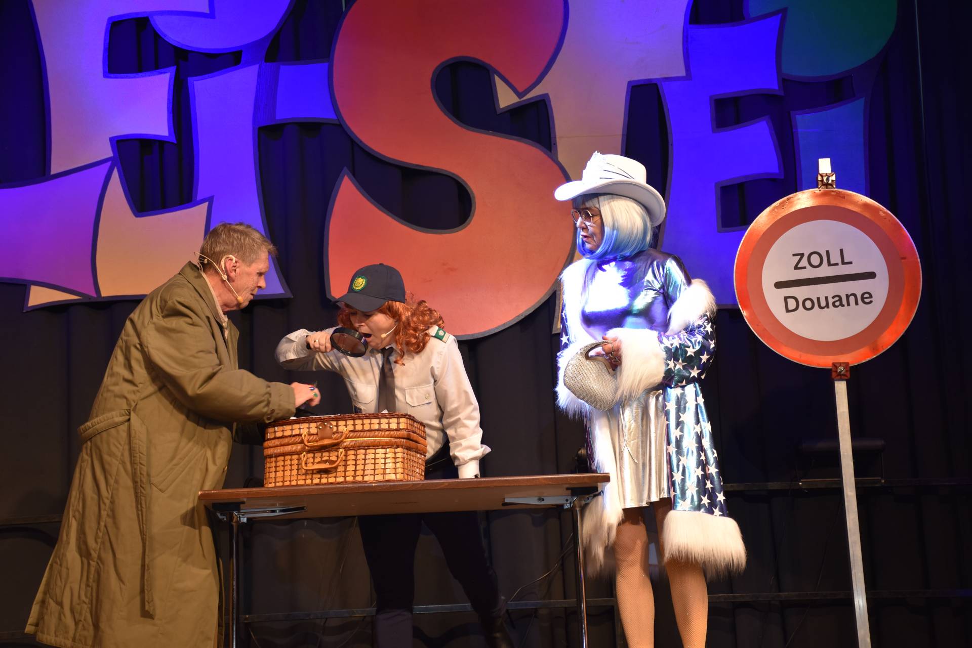 Beim Zoll: Ganz und gar nicht auff&auml;llig: 8 Uhren am Handgelenk, Juwelen am Hut, 4 Gold-Seidenjacken angezogen. Ulli Granig, Thomas Fellerer und Monika Safrin.