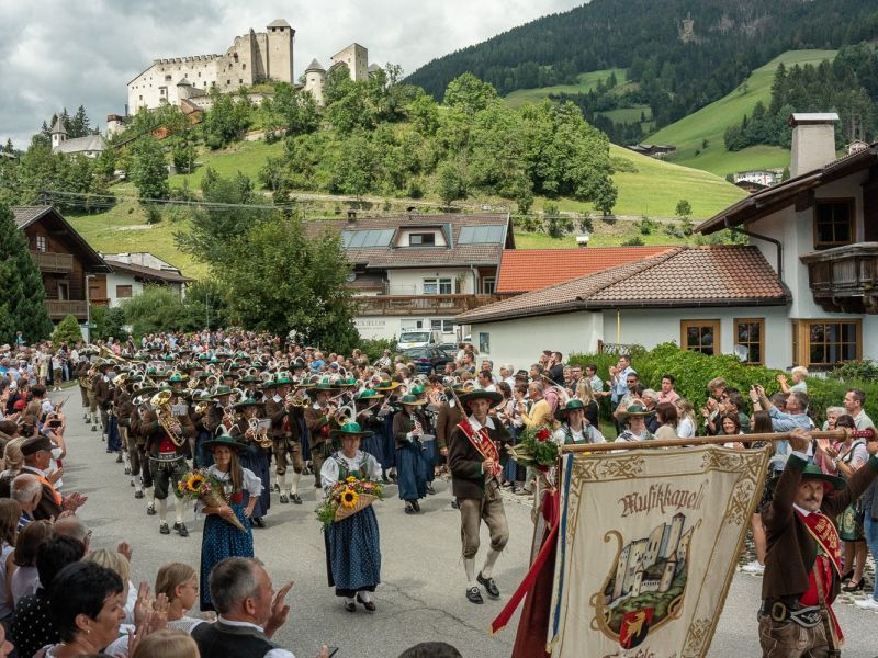 Die Musikkapelle Heinfels mit der Burg Heinfels im Hintergrund. 