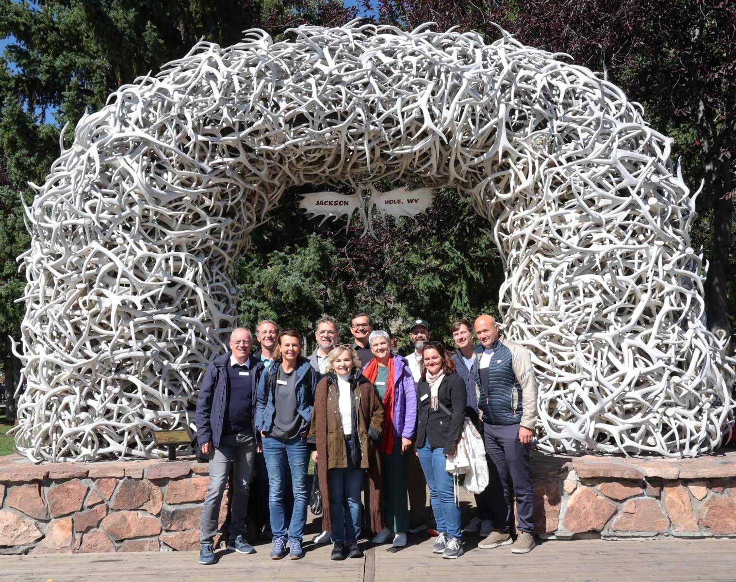 Die Delegation der Stadt Lienz mit Town Manager Tyler Sinclair (4.v.r.) vor einem der Antler Arches (B&ouml;gen aus abgeworfenen Geweihen) auf dem Town Square im Zentrum von Jackson/Wyoming, 21. September 2026 Foto:  Archiv Willi Lackner; Fotograf: Unbekannt