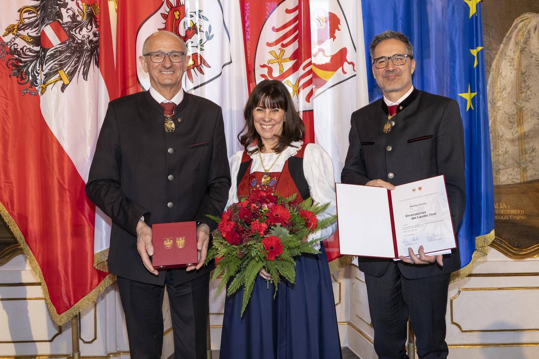 LH Anton Mattle und sein S&uuml;dtiroler Amtskollege Arno Kompatscher &uuml;berreichten Martha Schultz, Gesch&auml;ftsf&uuml;hrerin der Schultz-Unternehmensgruppe, das Ehrenzeichen des Landes Tirol.  Foto: Land Tirol/Die Fotografen